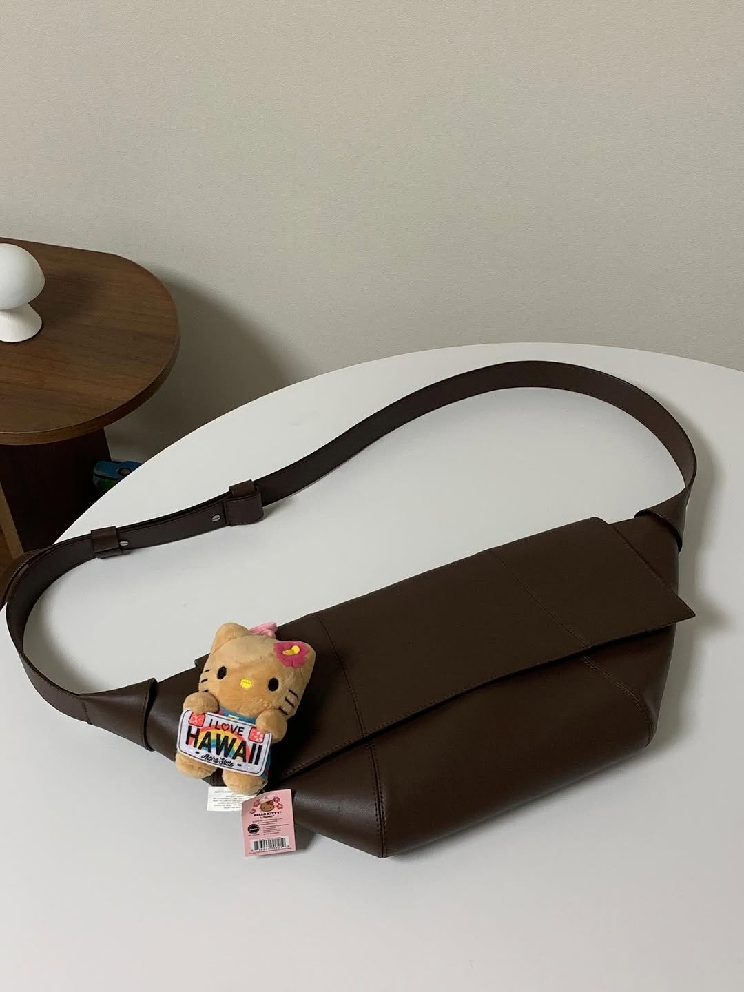 Photo shared by 고미 데일리룩 on November 05, 2025 tagging @kangdan_official. May be an image of saddle-stitched leather, purse, pencil case, sling and pouch.