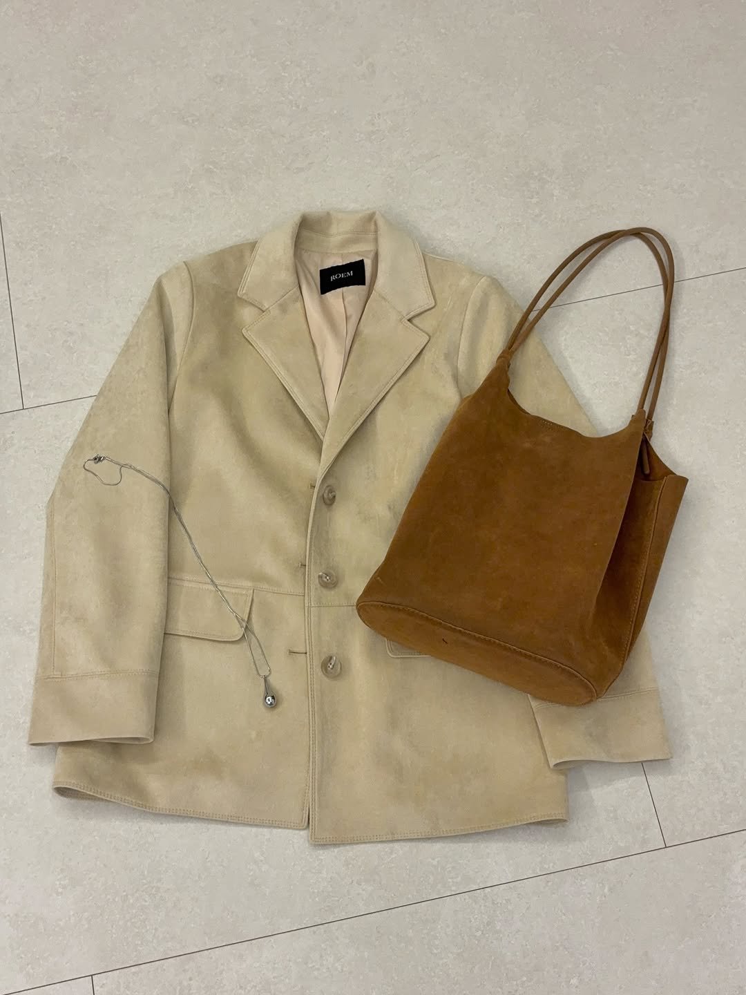 Photo by 고미 데일리룩 on February 18, 2026. May be an image of overcoat, blazer, purse, jacket and text.