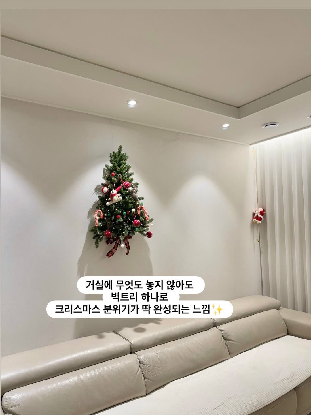 Photo by 단단홈 |삼남매엄마의 미니멀라이프 on November 20, 2025. May be an image of christmas tree, lighting, sofa, chaise lounge and text that says 'Cor 거실에 무엇도 놓지 않아도 벽트리 하나로 크리스마스 분위기가 딱 완성되는 느낌 國条小年茶'.