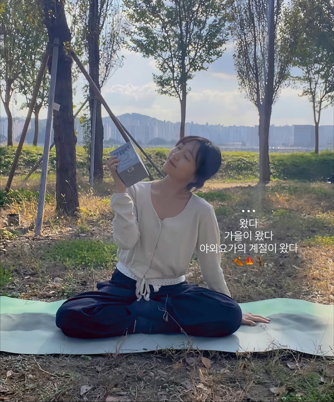 Photo shared by 송 단 | 요가, 라이프스타일 on October 25, 2025 tagging @daniiisong, and @veggiet.official. May be an image of yoga, park, picnic and text that says '왔다 가을이 왔다 야외요가의 계절이 왔다'.