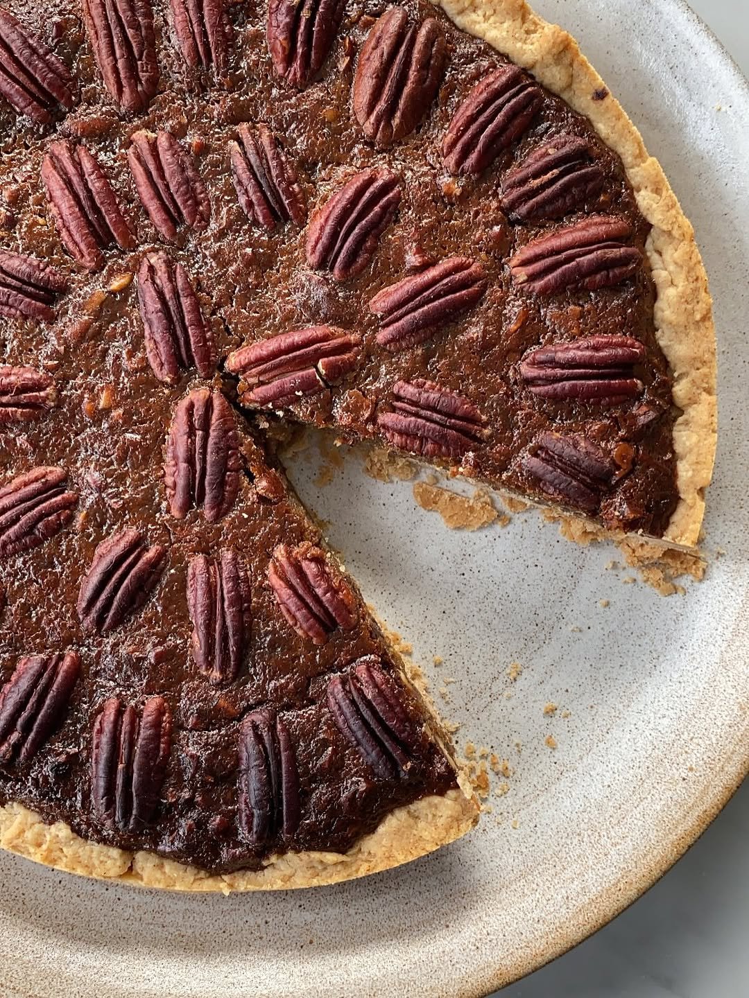 Photo by Deliciously Ella on November 22, 2025. May be an image of tart, pecans, pie and text.