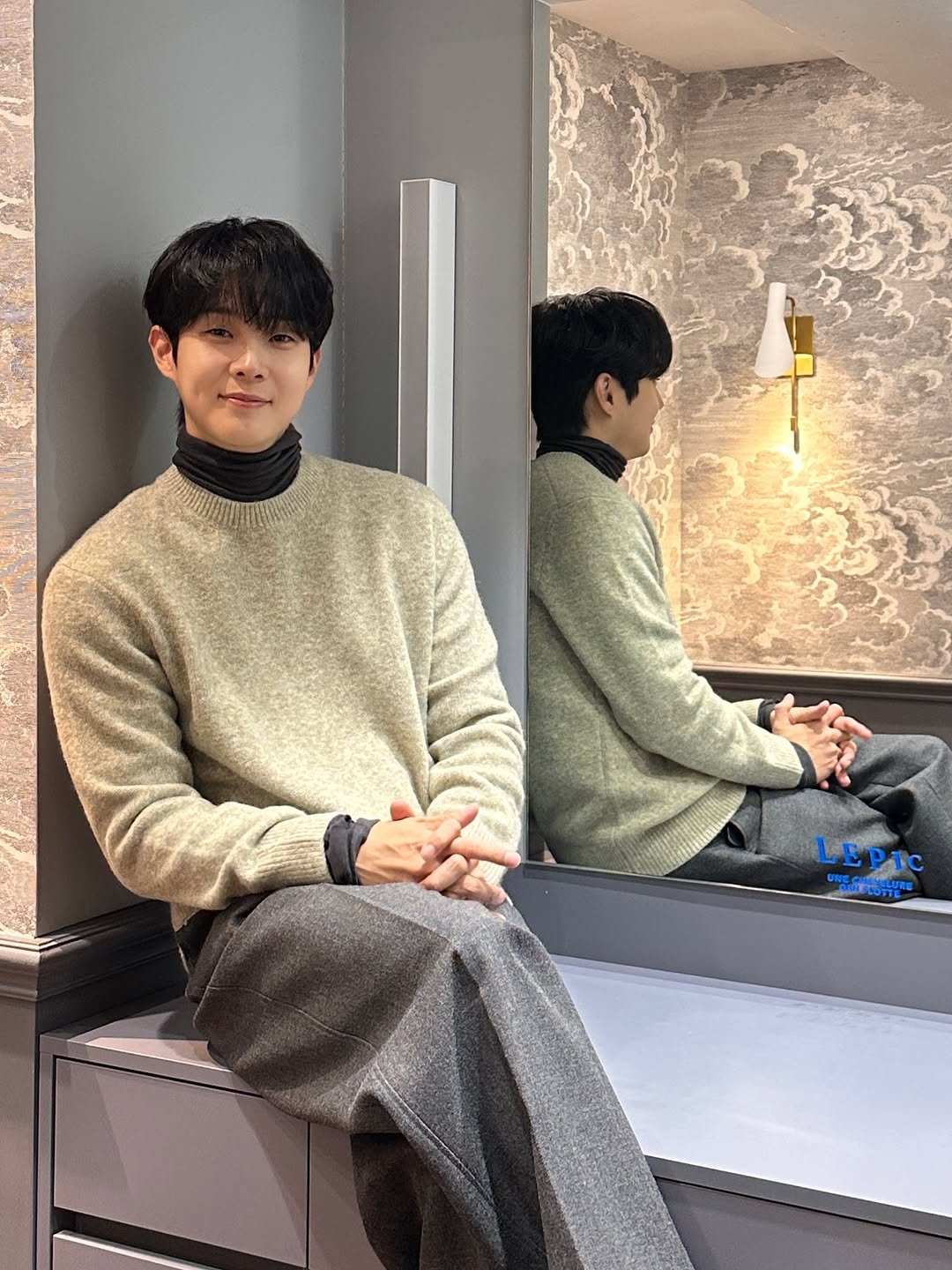 Photo shared by CHOIWOOSHIK on October 23, 2025 tagging @projectm_official_, and @lepic_cheongdam. May be an image of duffle coat, overcoat, sweatpants, turtleneck and mirror.