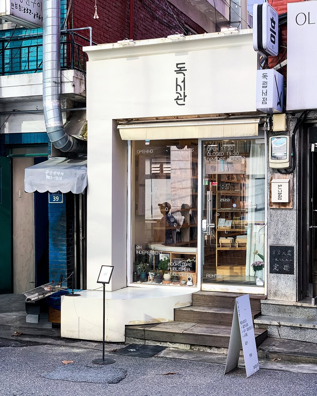 Photo by 독서관 in 독서관. May be an image of 1 person, signboard, newsstand, street, buildings and text.