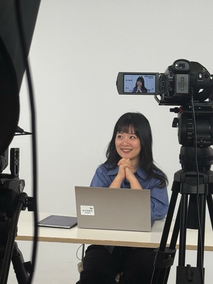 Photo shared by 물결점 on February 10, 2026 tagging @heresmina, @dongasiabook, and @kyobobook_online. May be an image of one or more people, camcorder, camera, microphone, tripod, office and text.