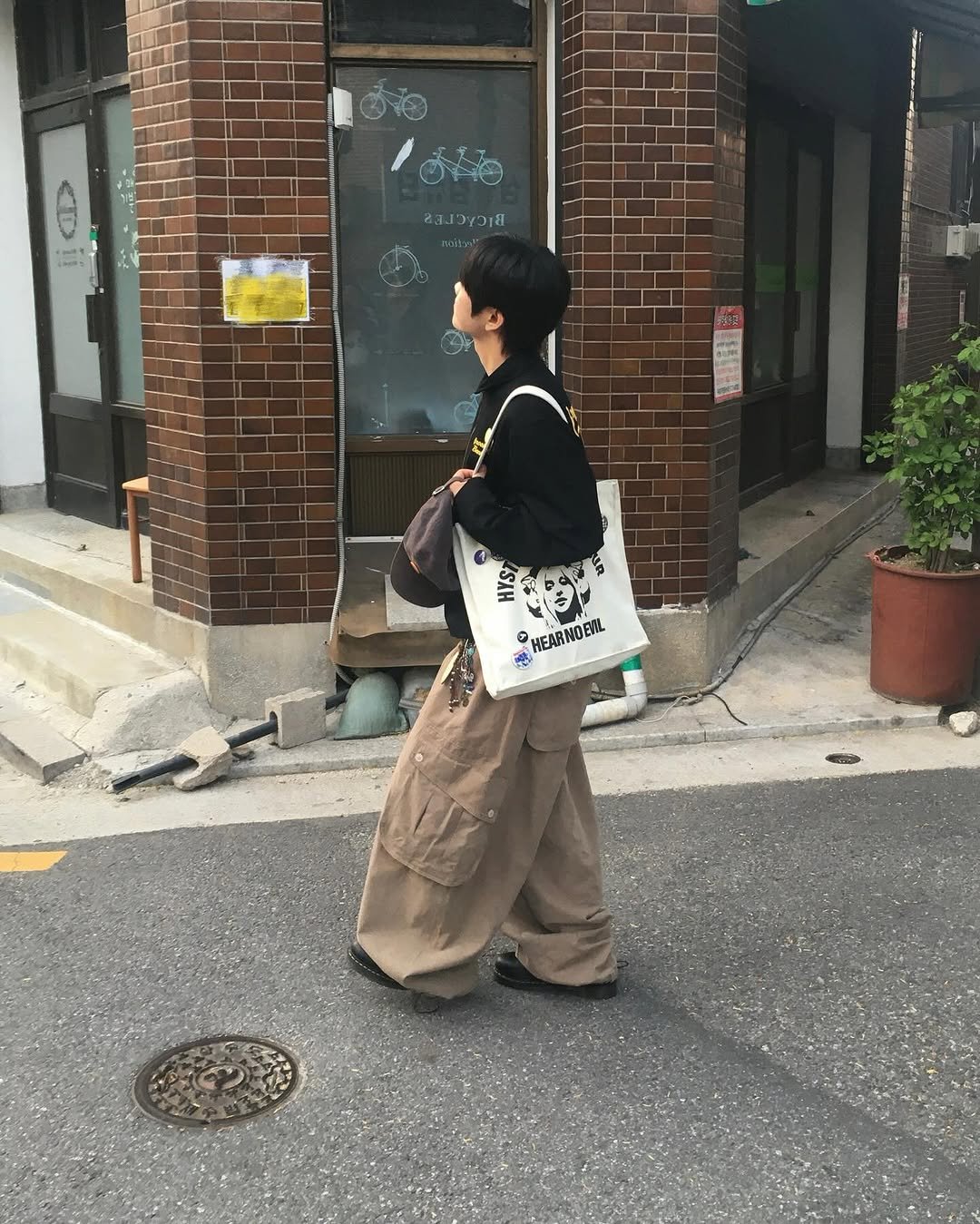 Photo shared by 동현 / 투븐 TOVN on September 23, 2025 tagging @tovn_official. May be an image of 1 person, duffle coat, overcoat, grocery bag, cornflower, street and text.