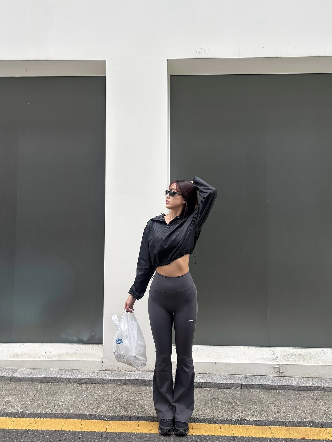 Photo shared by 이식로그🫧 on November 09, 2025 tagging @hdex__official, and @hdex_women. May be an image of one or more people, activewear, sweatpants, plastic bag, tights, sportswear, road, street and text.