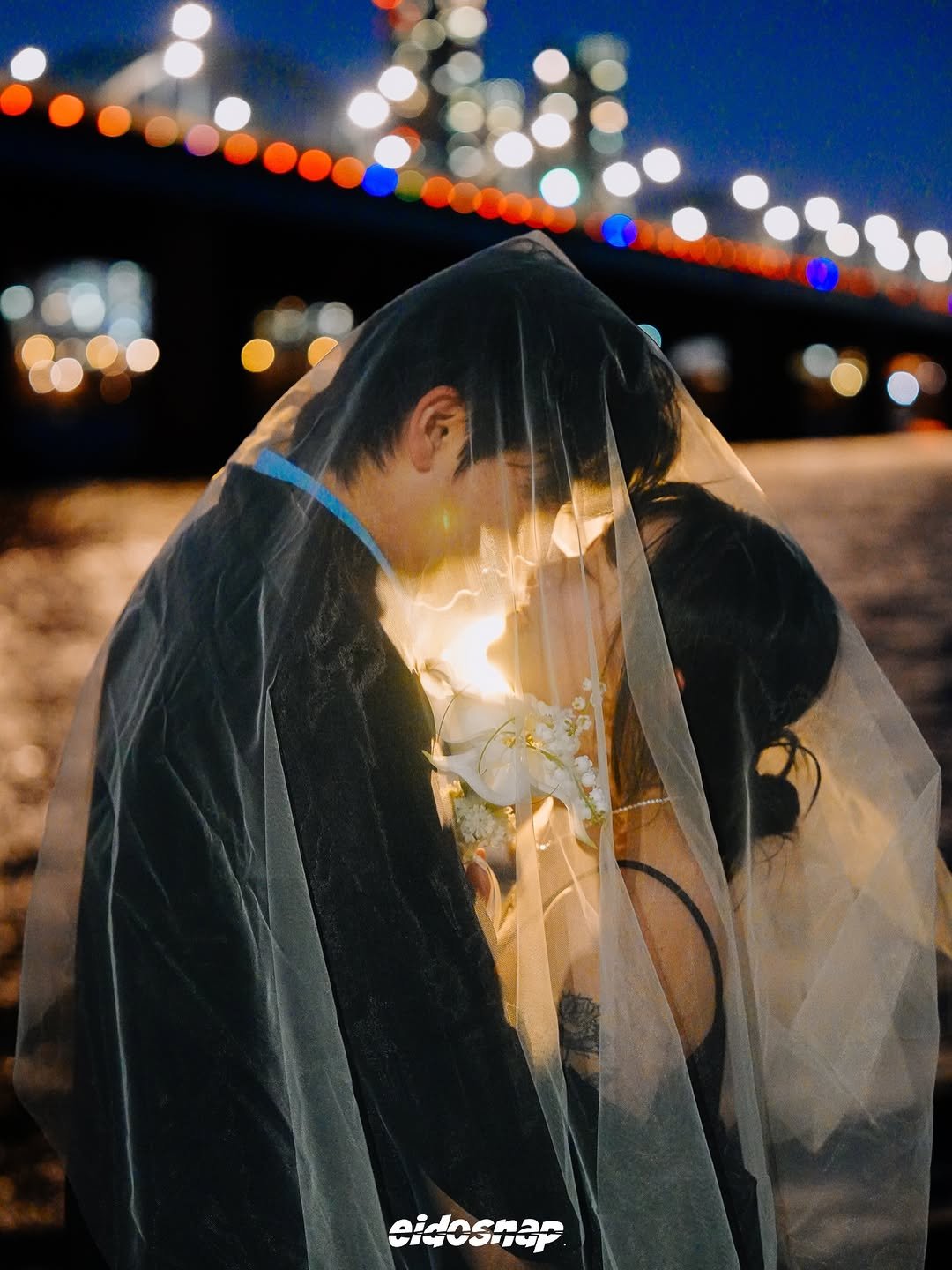 Photo by 이도스냅 | 힙한웨딩스냅 | 웨딩스냅작가 on February 22, 2026. May be an image of people kissing, the Brooklyn Bridge, wedding and text that says 'eidosnar'.