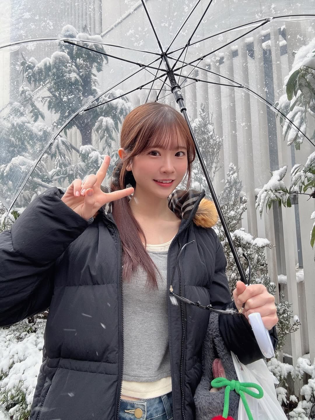 Photo by 白上咲花 on February 07, 2026. May be an image of duffle coat, umbrella, parka, parasol, raincoat, snow and text.