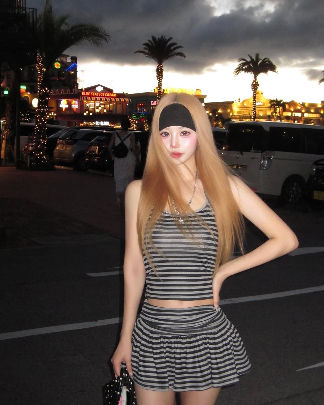 Photo by SUJIN ♥ on July 02, 2025. May be an image of 1 person, blonde hair, headscarf, beret, fishnet stockings, miniskirt, street and text.