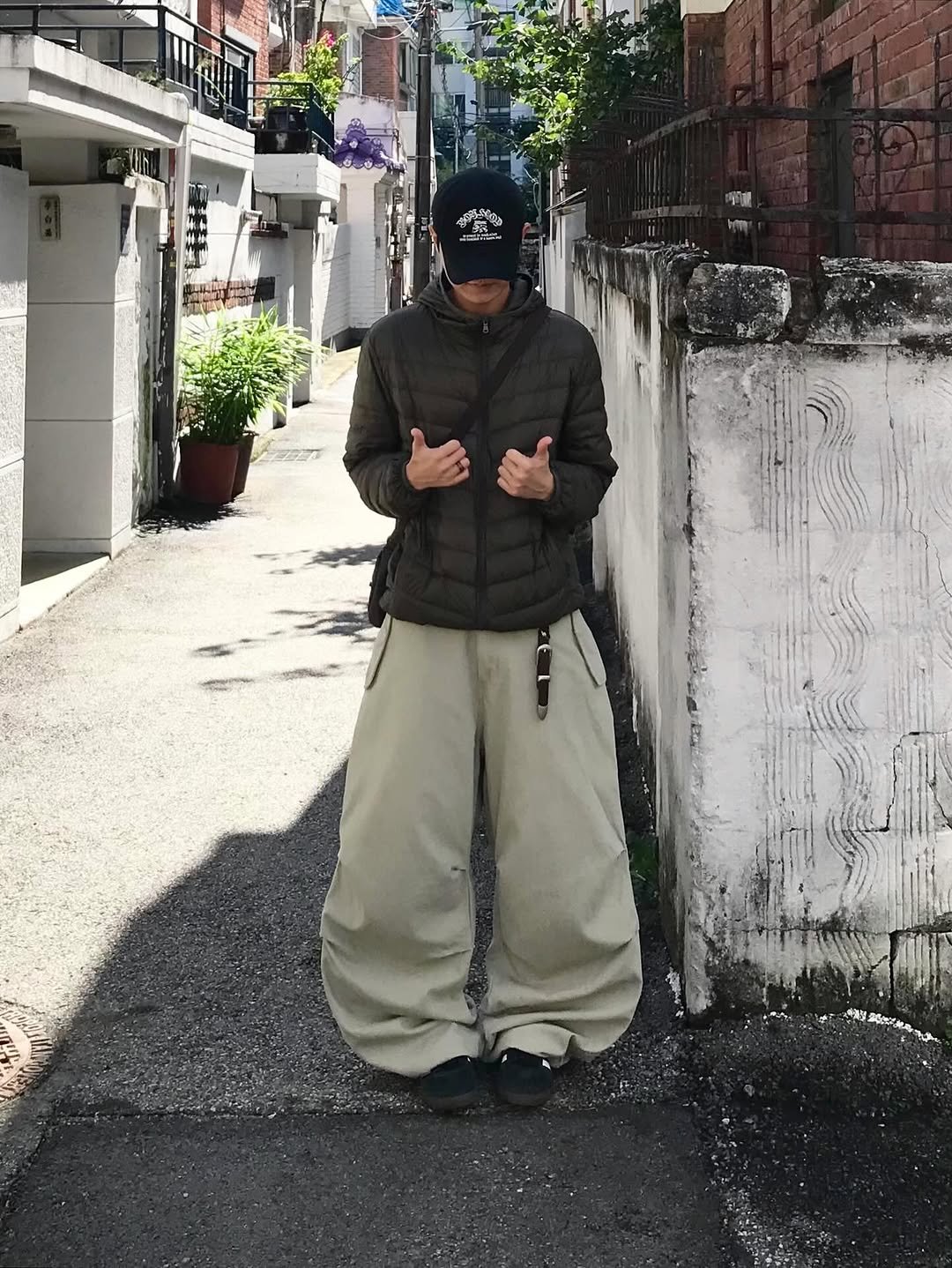 Photo shared by 동우 / 이퀄 on October 31, 2025 tagging @equal_kr. May be an image of goosedown coat, overcoat, duffle coat, face mask, parka, sweatpants, street and text.