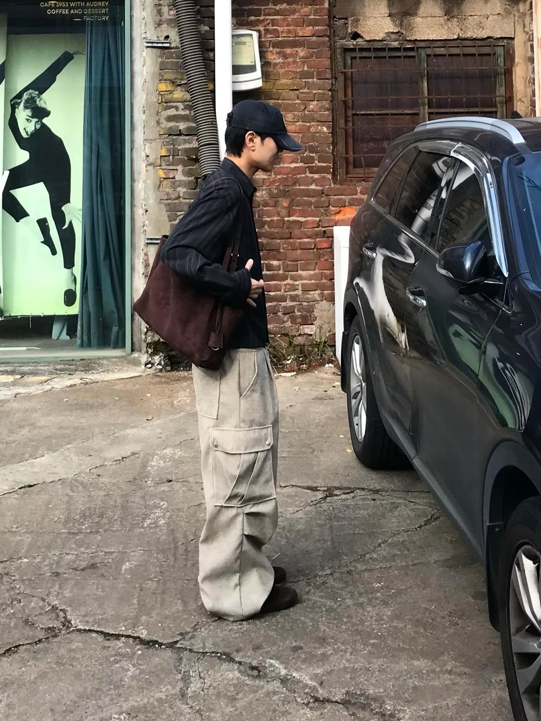 Photo shared by 동우 / 이퀄 on December 21, 2025 tagging @equal_kr. May be an image of standing, tool bag, wingtip shoes, outerwear, street and text.