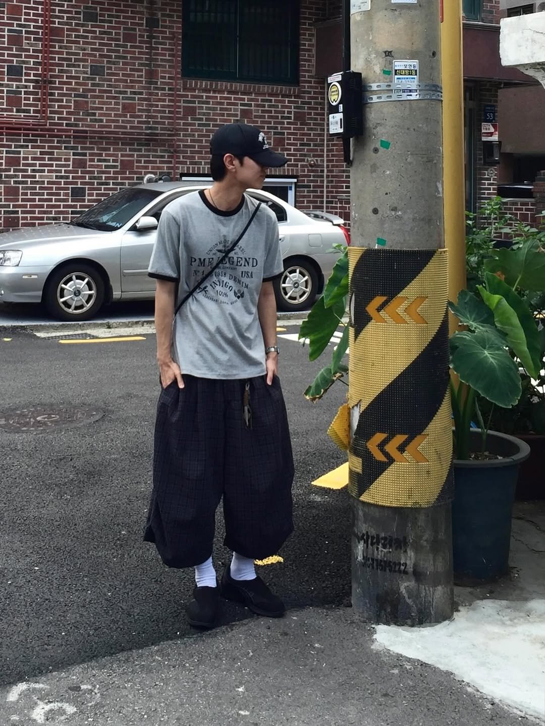 Photo by 동우 / 이퀄 on August 13, 2025. May be an image of 1 person, kilt, sarong, sweatpants, street, telephone pole and text.
