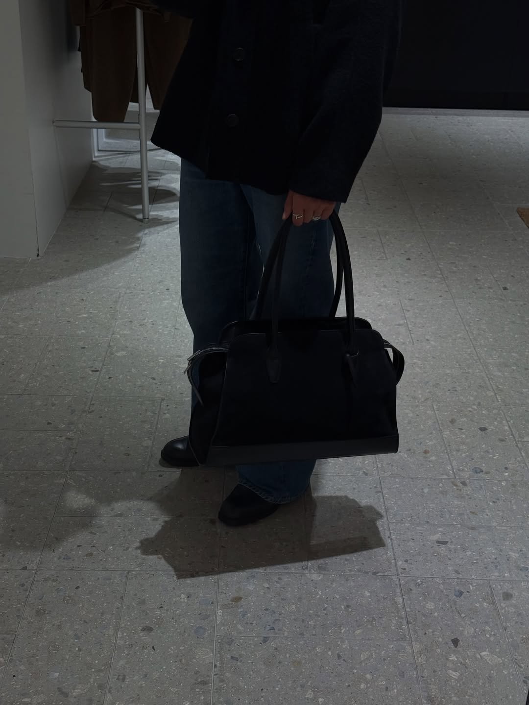Photo by eric park on February 26, 2026. May be an image of duffle coat, overcoat, purse, briefcase, luggage and text.
