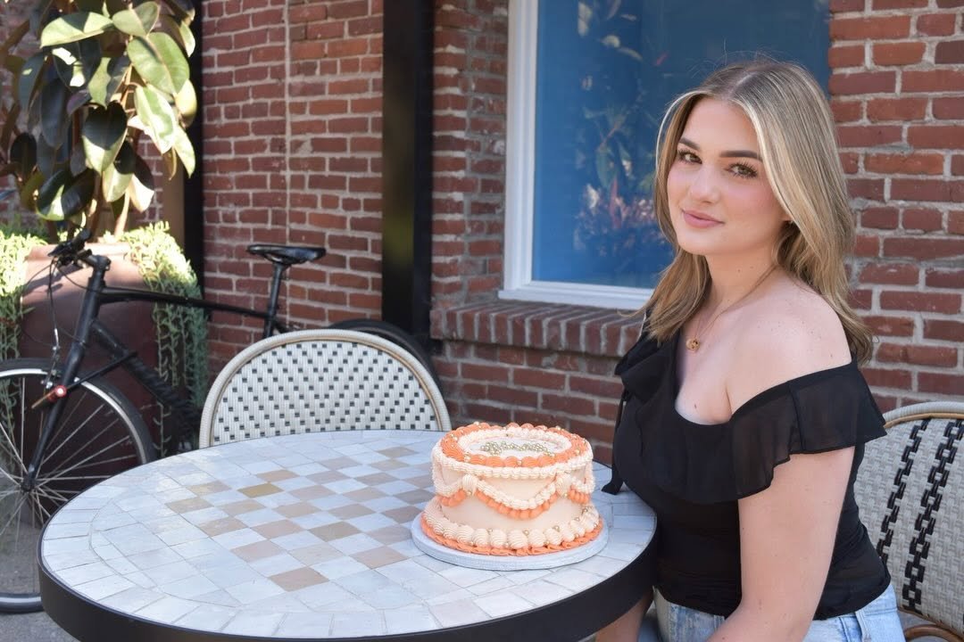 Photo shared by SARA | Cosmetic Tattoo Artist & Trainer on April 14, 2026 tagging @angels.confections. May be an image of cake, sundress, brick wall and text.