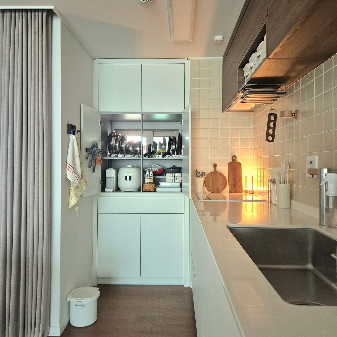 Photo by 은하수 on July 20, 2025. May be an image of kitchen island, sink, range hood, curtains, countertop, rack, indoors, kitchen and text.