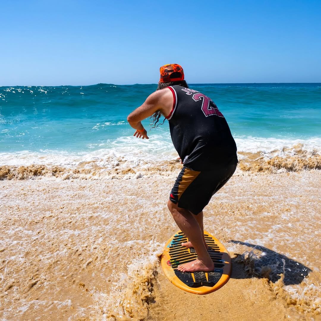 Photo shared by George Bryan on April 22, 2026 tagging @exileskimboards. May be an image of surfboard, frisbee, wetsuit, water, beach and text.