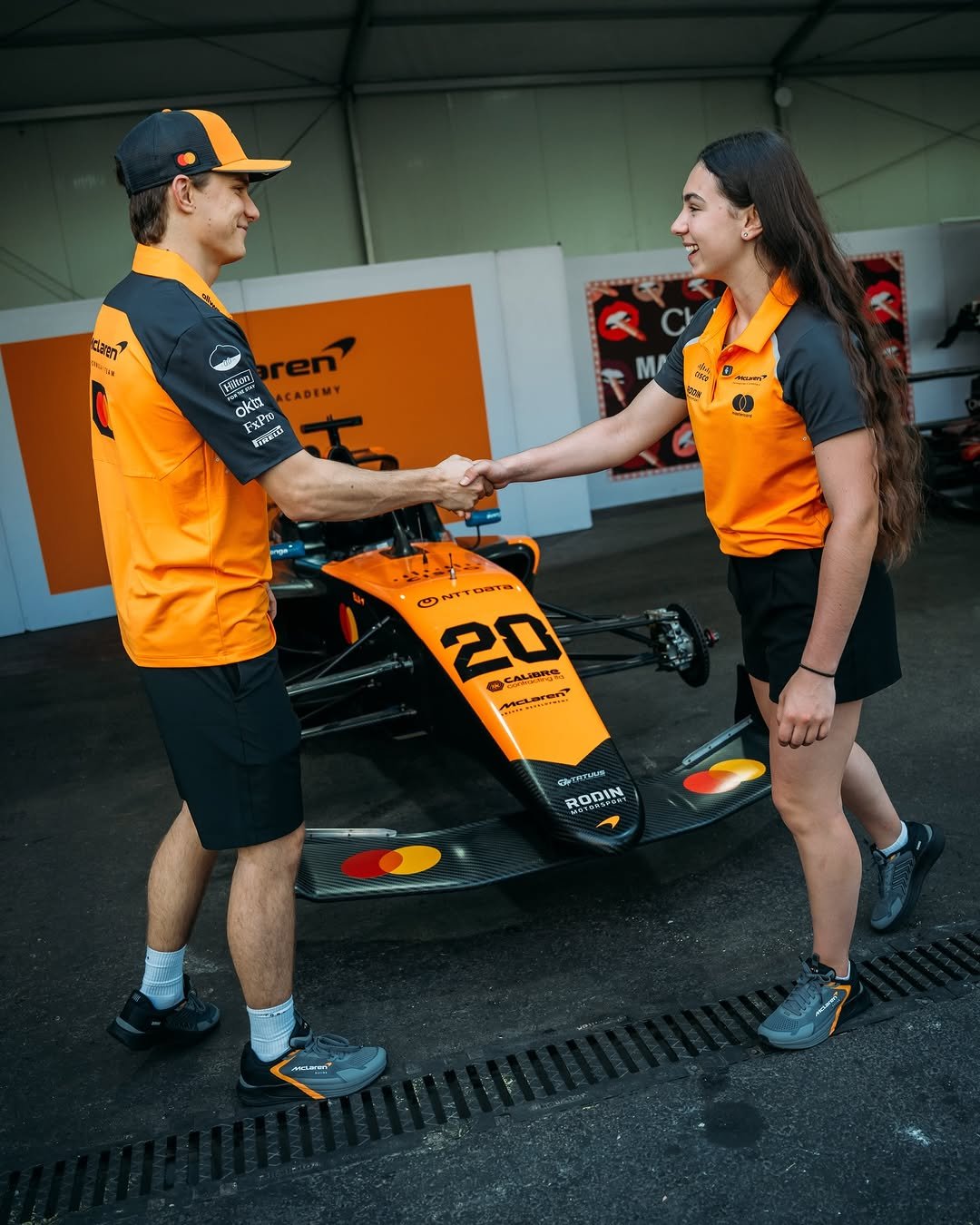 Photo shared by F1 Academy on January 05, 2026 tagging @mclaren, @oscarpiastri, and @ellalloyd. May be an image of racing vehicles, helmet and text.