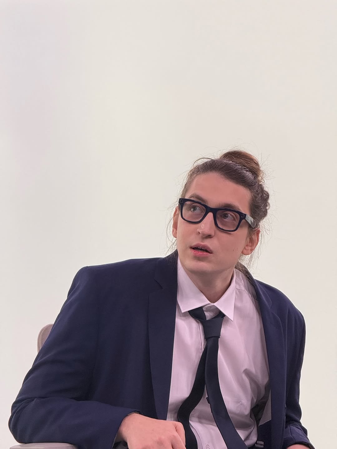 Photo by Felipe Bressanim on March 22, 2026. May be an image of one or more people, eyeglasses, wingtip shoes, bolo tie, suit, blazer and text.