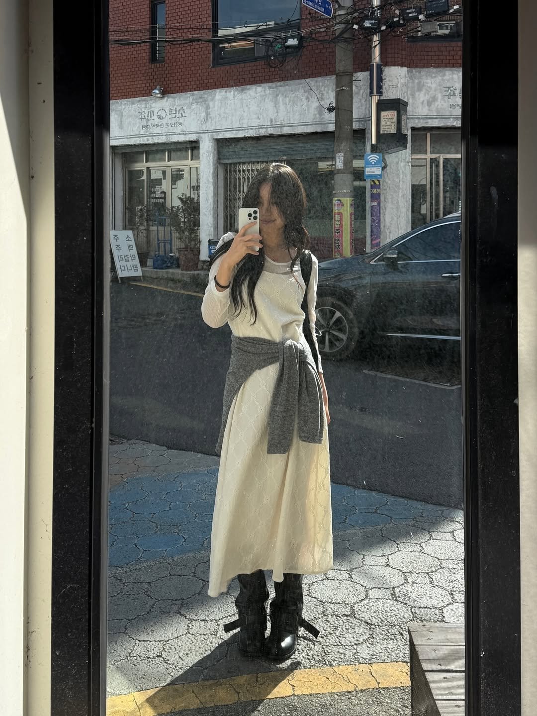 Photo by 포밍뮤즈 on April 13, 2026. May be an image of overcoat, cloak, kilt, cardigan, window and text.