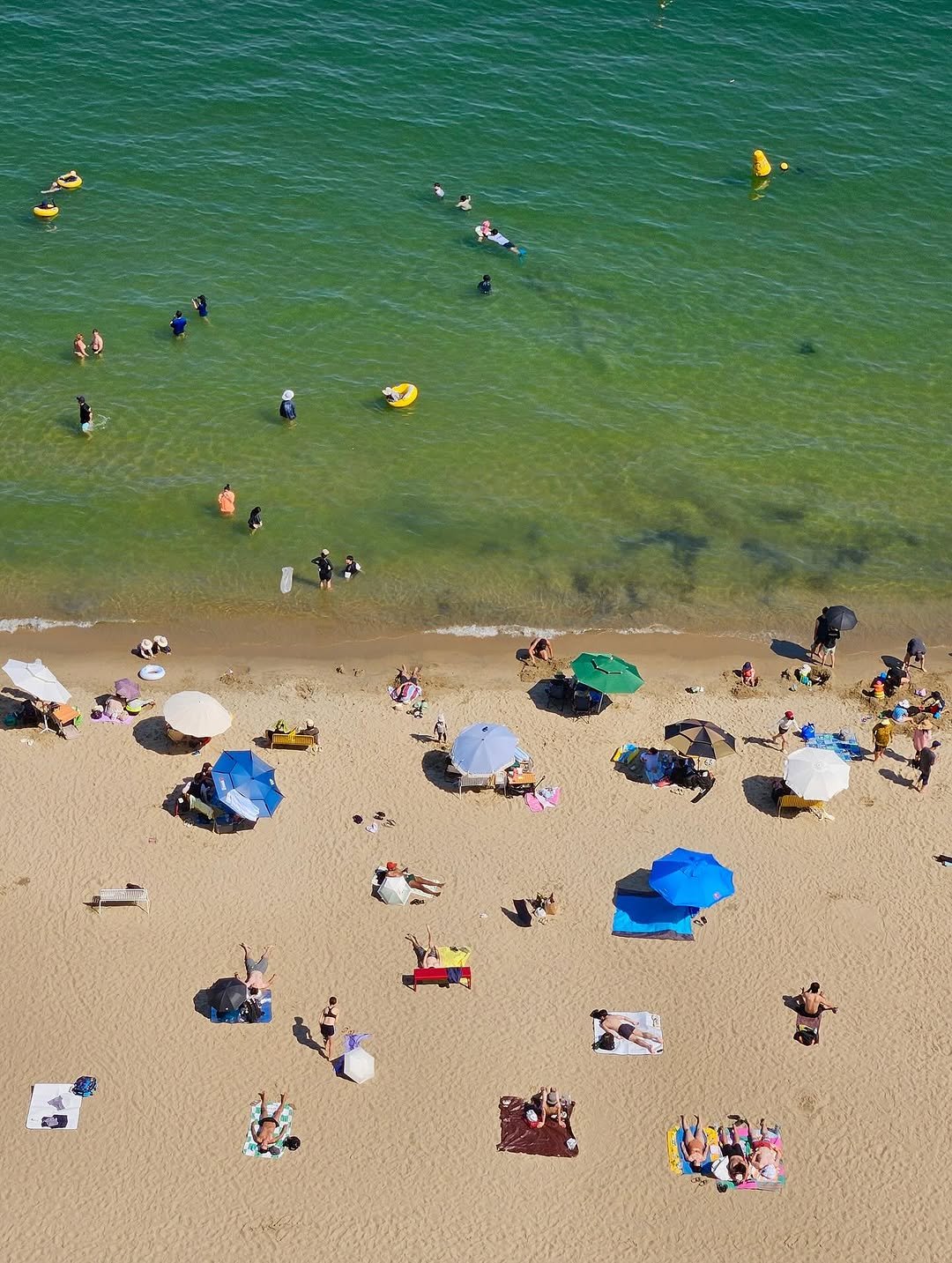 Photo by Kim Shinji on August 20, 2025. May be an image of 2 people, umbrella, parasol, beach, coast and text.