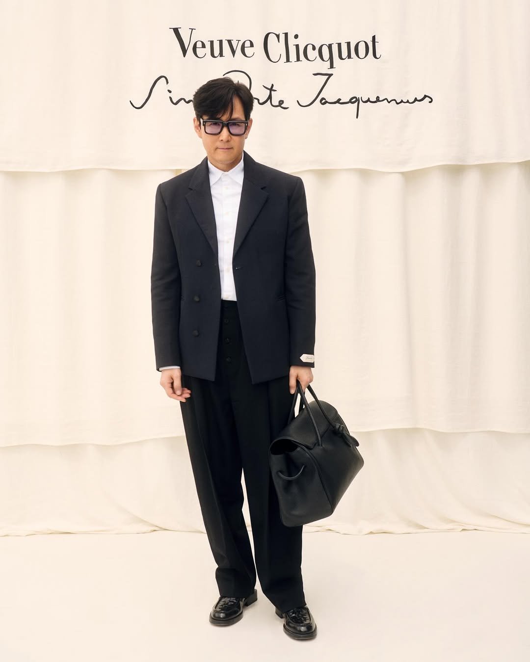 Photo by Lee jung jae on April 02, 2026. May be an image of overcoat, duffle coat, suit, dinner jacket, blazer and text that says 'VeuveClicquot Veuve Clicquot te Janqunus'.