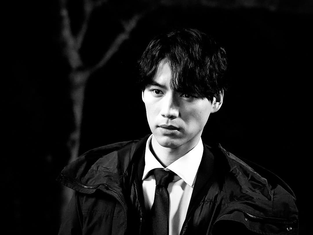 Photo by Sota Fukushi on March 17, 2026. May be a black-and-white image of one or more people, bangs, duffle coat, overcoat, cigarette, bolo tie and text.