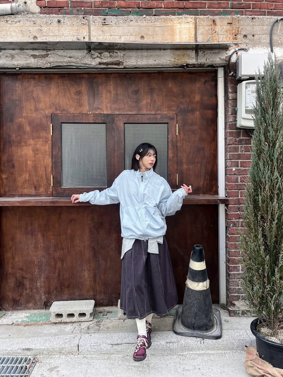 Photo shared by 세영 on March 03, 2026 tagging @dkonlinestore_official. May be an image of duffle coat, brick wall and text.