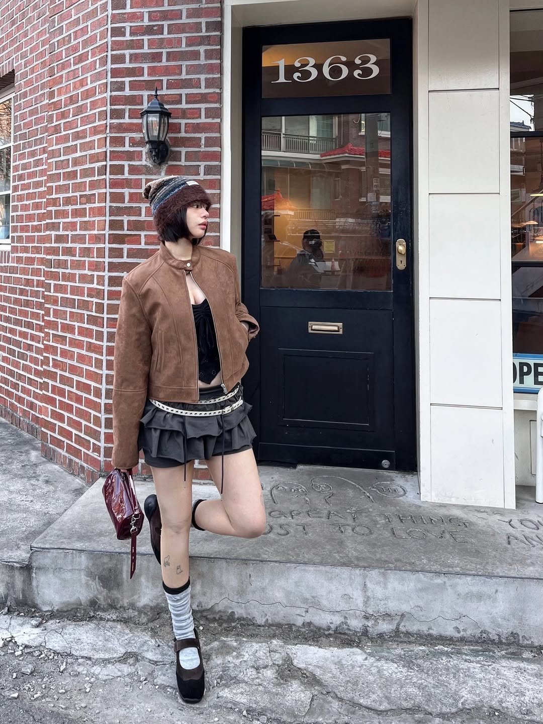 Photo shared by 세영 on February 09, 2026 tagging @saintsatin__official. May be an image of duffle coat, overcoat, fur coat, headscarf, beret, turtleneck, kilt, miniskirt, parka and text.