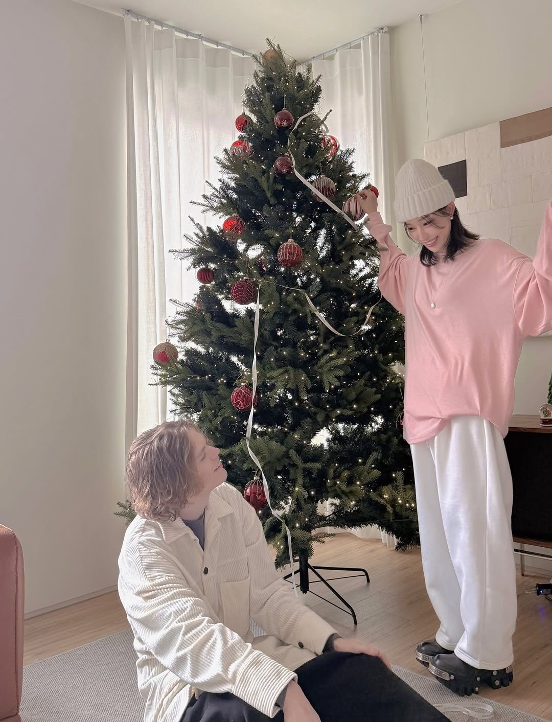 Photo by Jihye Seo on December 24, 2025. May be an image of sleepwear, christmas tree, sweater, bath robe, tinsel, sweatpants and text.