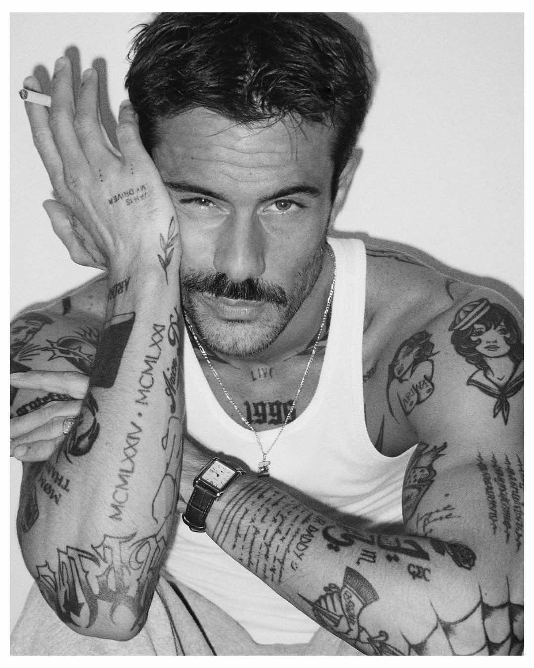 Photo by ga on October 24, 2025. May be a black-and-white image of one or more people, beard, tattoo, people smoking, cigarette and text.