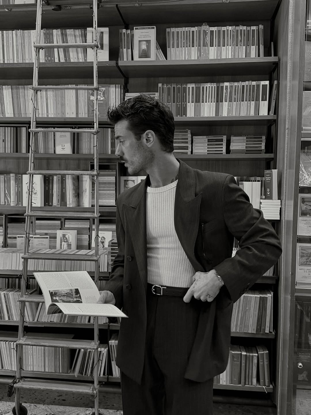 Photo by ga on November 12, 2025. May be a black-and-white image of one or more people, overcoat, suit, dinner jacket, newspaper, newsstand and text.