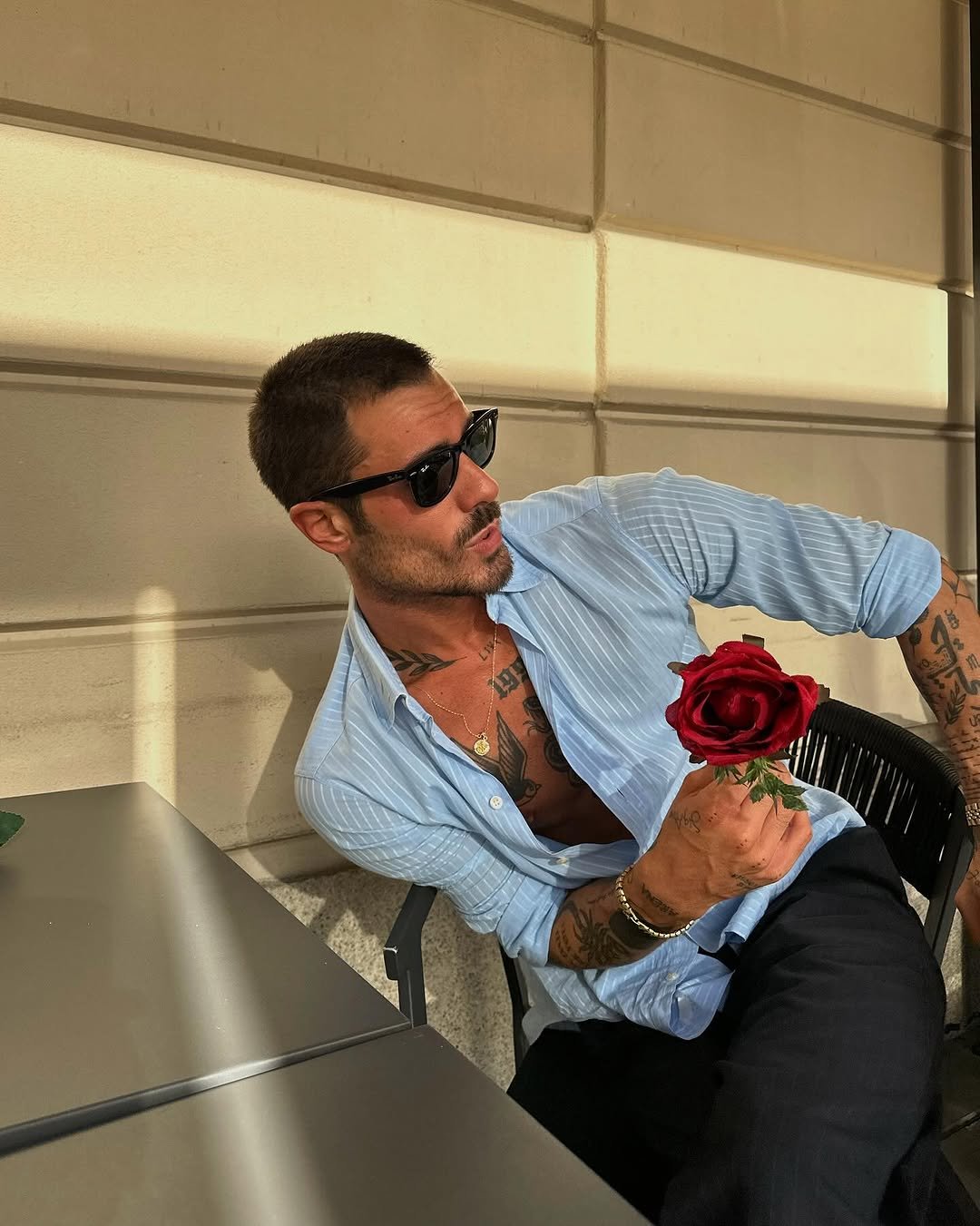 Photo shared by ga on July 15, 2025 tagging @rayban, and @ougiegold. May be an image of one or more people, wrist watch, carnation and rose.