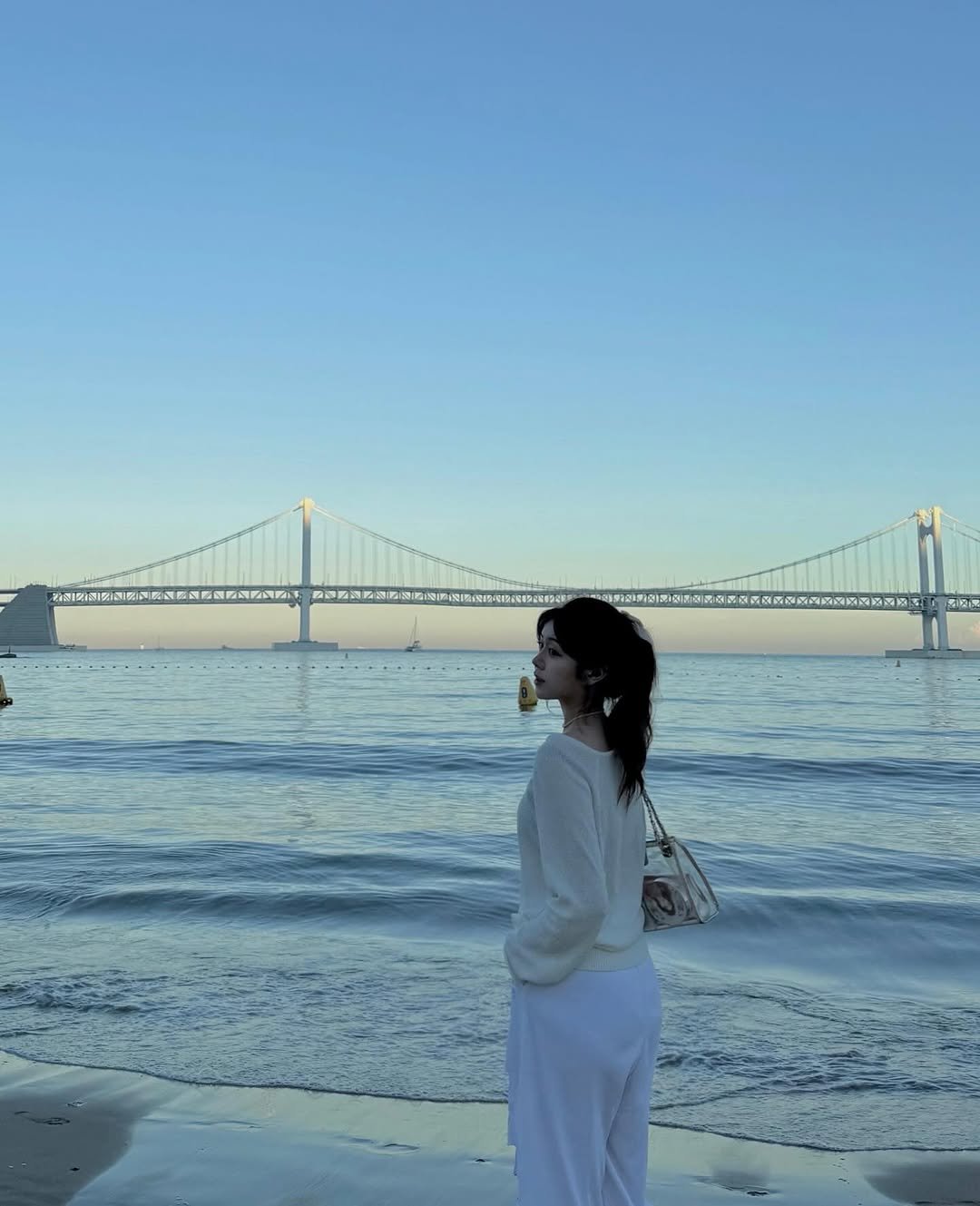 Photo by 가영 on July 24, 2025. May be an image of 1 person, ocean, coast, suspension bridge and text.