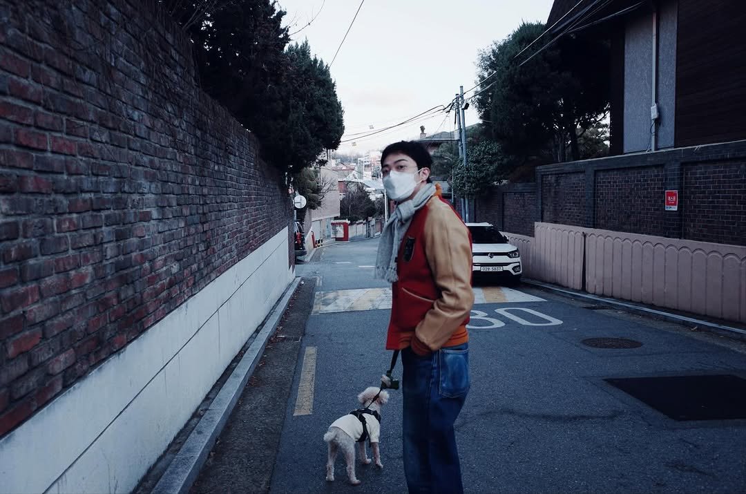 Photo by 기리보이 WSH on December 31, 2025. May be an image of duffle coat, overcoat, cigarette, face mask, street and text.