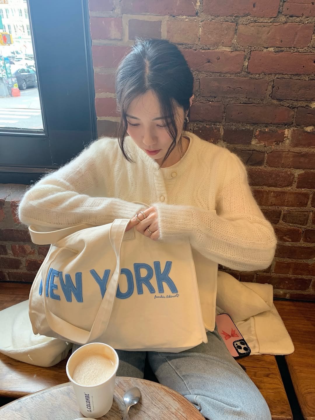 Photo shared by 곰송이 Songyi Moon on November 07, 2025 tagging @frankiesbikinis, and @thelille_official. May be an image of coffee cup, sweater, cornflower and text.