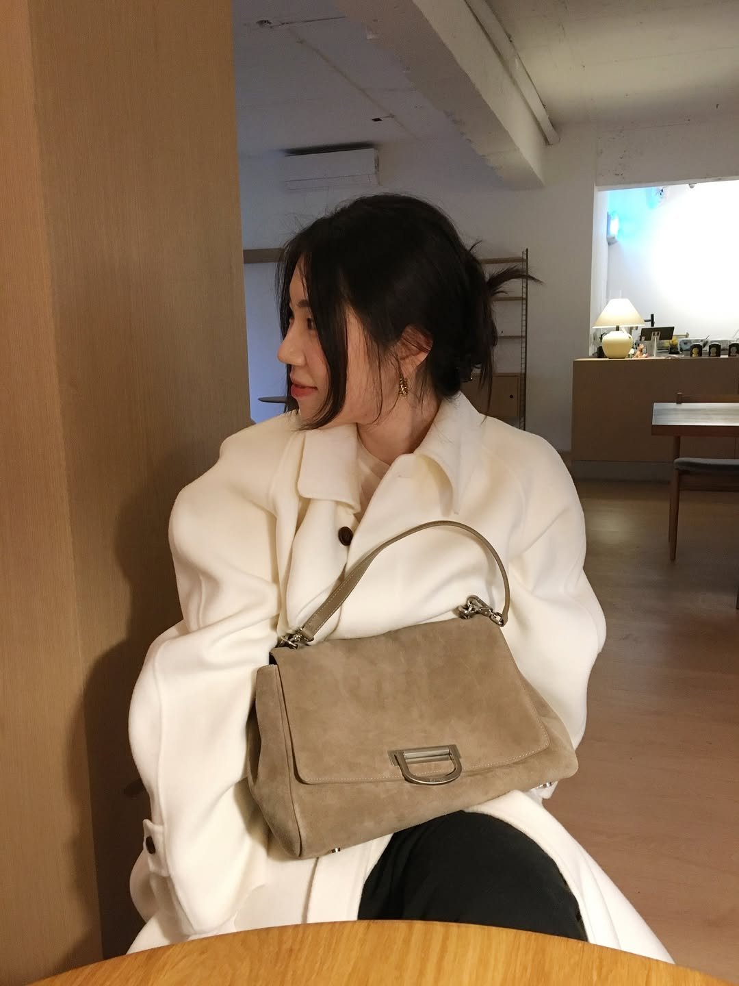 Photo shared by 곰송이 Songyi Moon on December 17, 2025 tagging @elbategev. May be an image of one or more people, hair, duffle coat, purse, clutch and text.