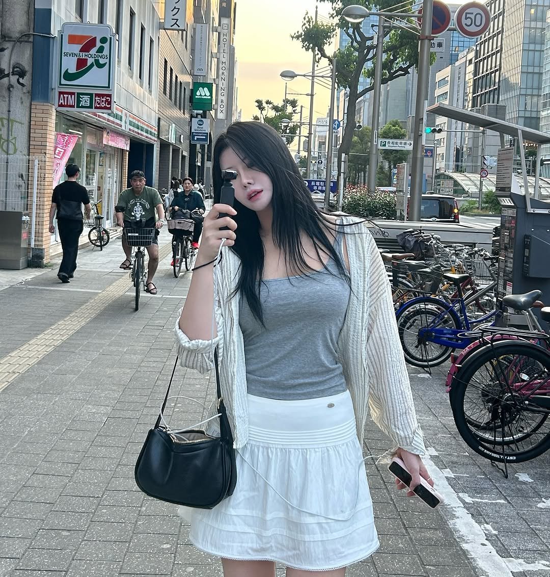 Photo by 흿 on June 19, 2025. May be an image of 3 people, miniskirt, street and text.
