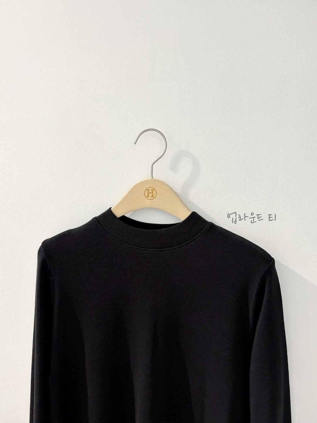 Photo by 에이치에뜨레 김해점 on December 19, 2025. May be an image of clothes hanger, fleece, top, turtleneck, sweatshirt and text that says '업라운드 업라운드티 El'.