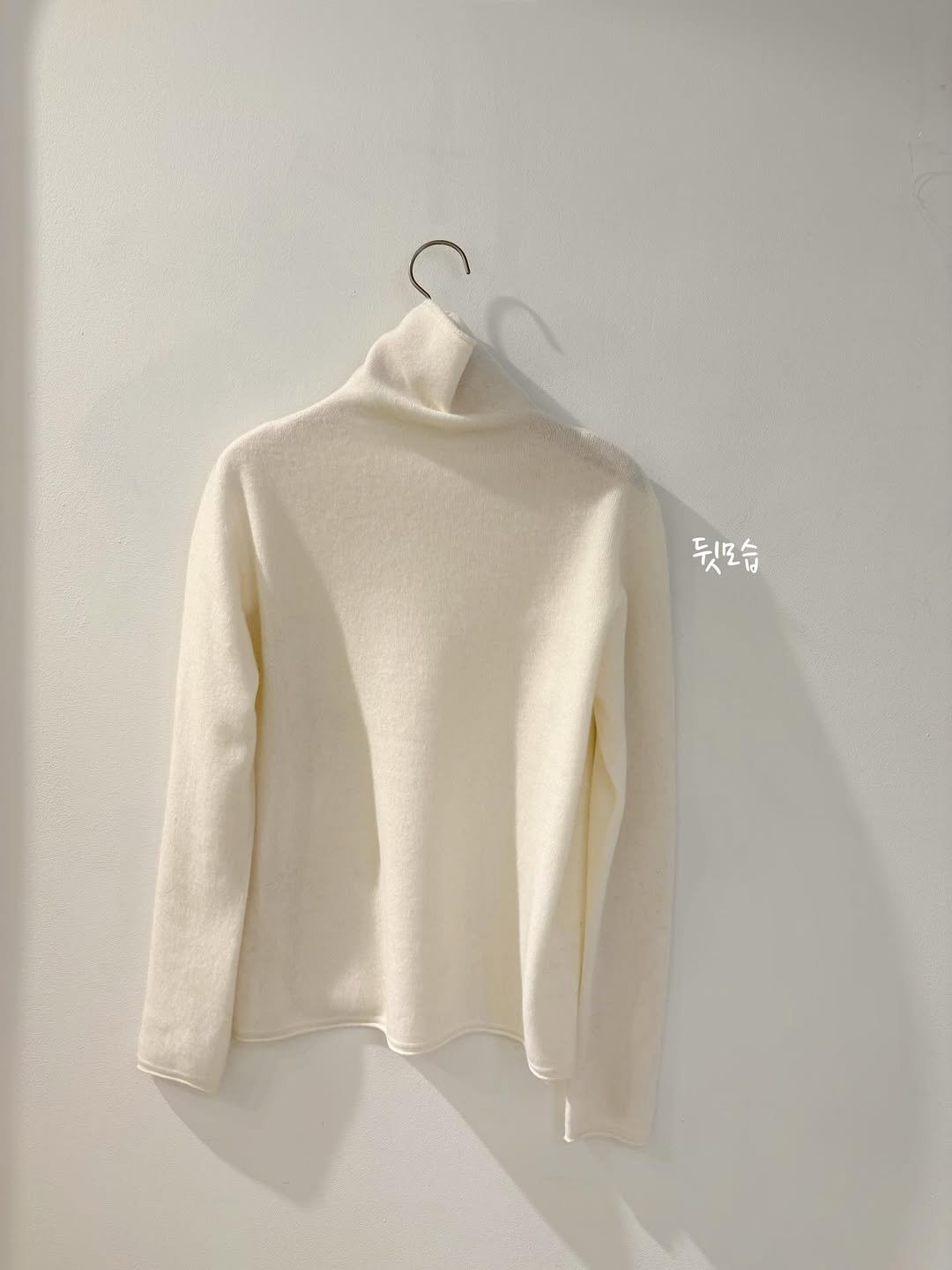 Photo by 에이치에뜨레 김해점 on December 25, 2025. May be an image of top, turtleneck, clothes hanger and text.
