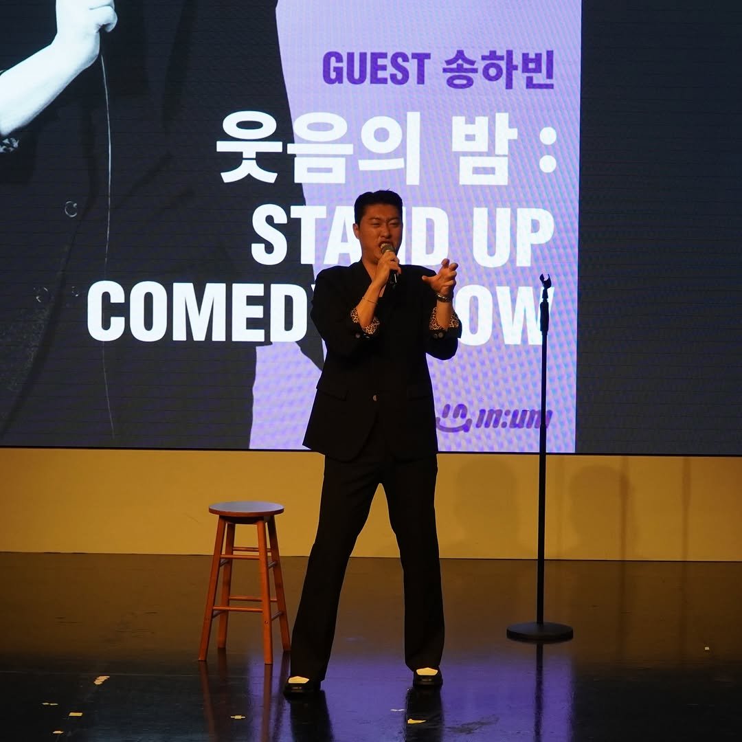 Photo by 송하빈 on November 28, 2025. May be an image of microphone and text that says 'GUEST 송하빈 웃음의 밤 STARDUP D UP STA COMED OИ'.
