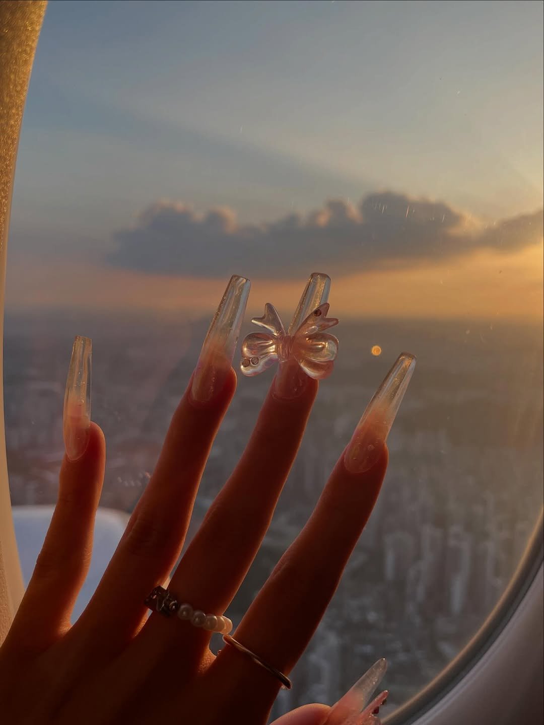 Photo by 하봄 on January 11, 2026. May be an image of one or more people, fingernails, ring, airplane and text.
