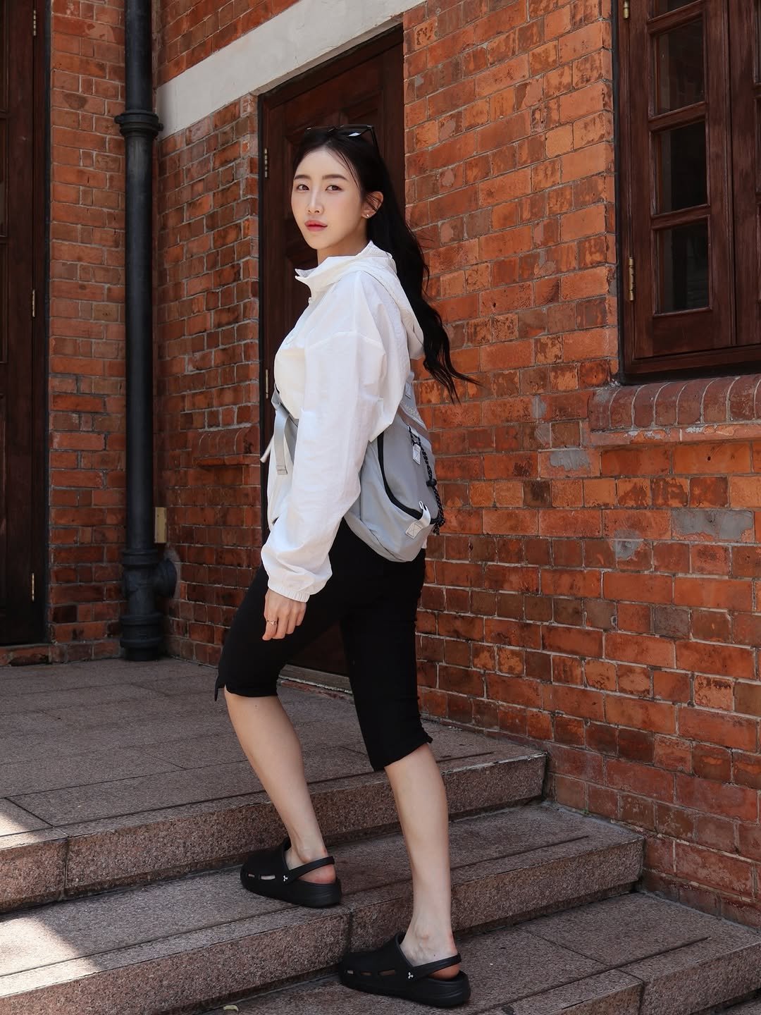 Photo by 해롱이 ❤️ on April 25, 2026. May be an image of outerwear, slingback shoes, top, brick wall and text.