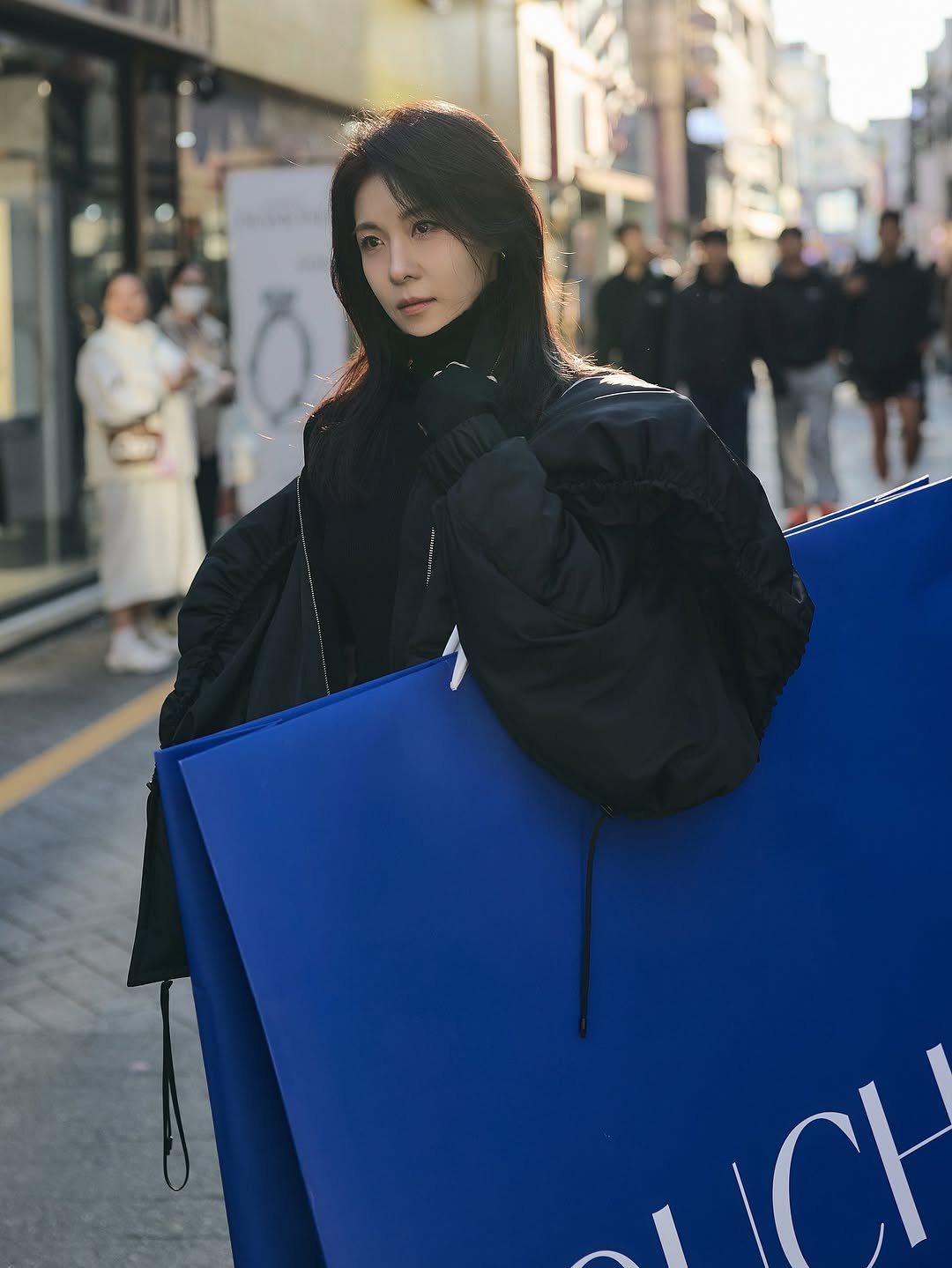 Photo by 하지원 on November 14, 2025. May be an image of one or more people, people standing, overcoat, goosedown coat, duffle coat, parka, street and text.