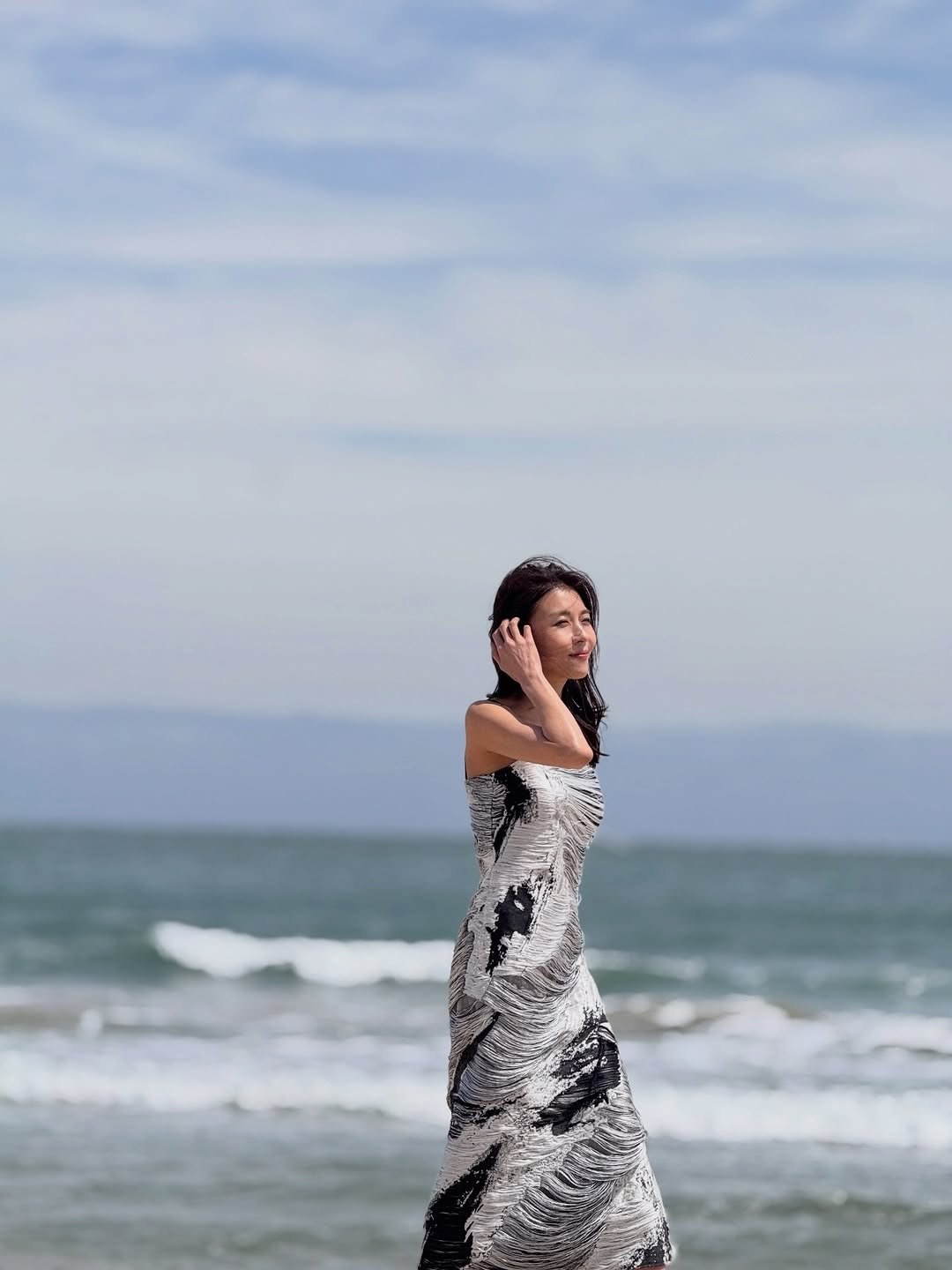 Photo by 하지원 on April 21, 2026. May be an image of sundress, gown, sarong, ocean, coast and text.