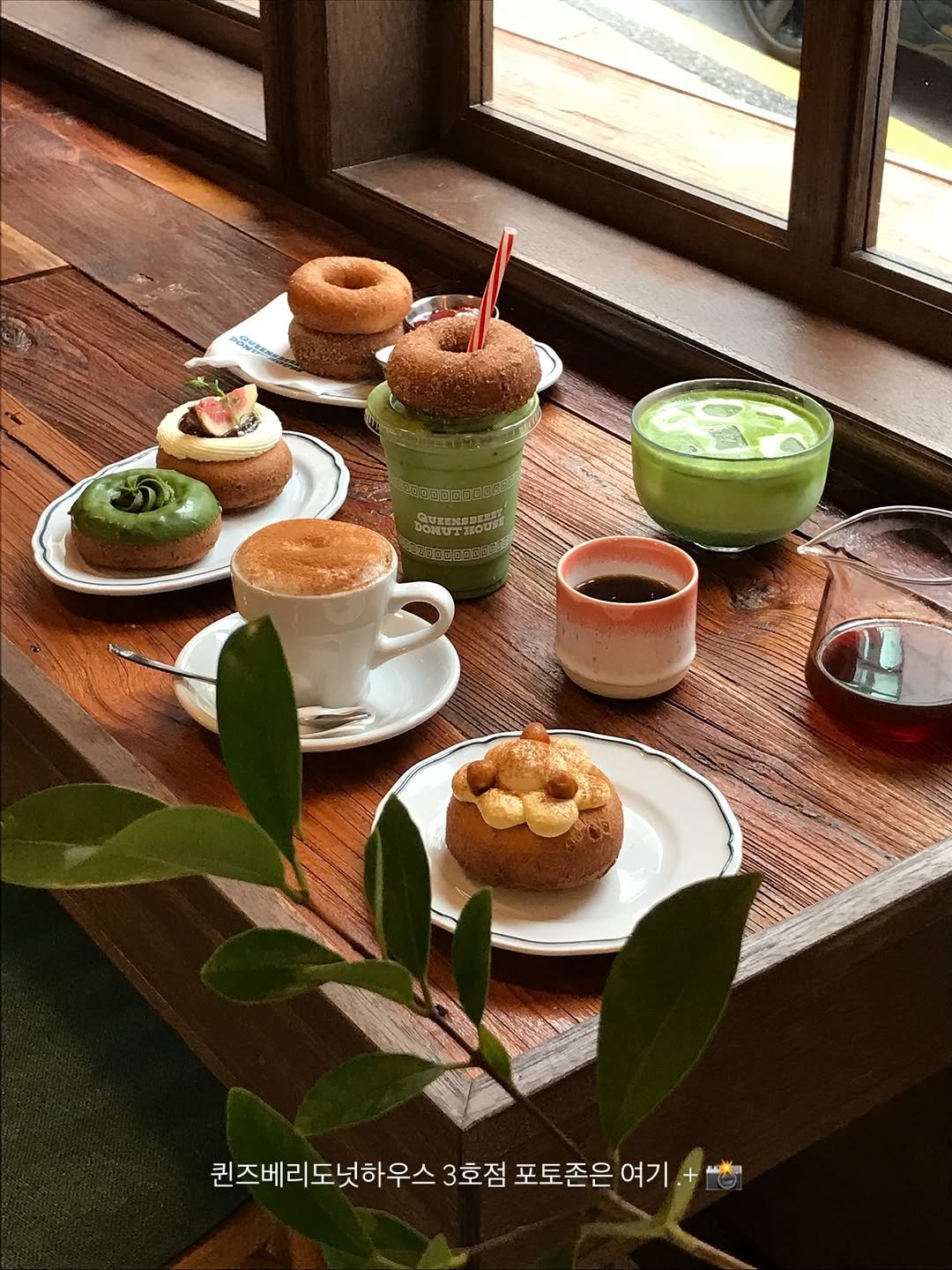Photo shared by 한 컾 | 카페 • Cafe on September 28, 2025 tagging @queensberry.donut.house. May be an image of cake, coffee cup, souffle, tart, coffee, bagel, tea, teacup and text that says 'കൊ 퀸즈베리도넛하우스 3호점 포토존은 여기 몸볶'.