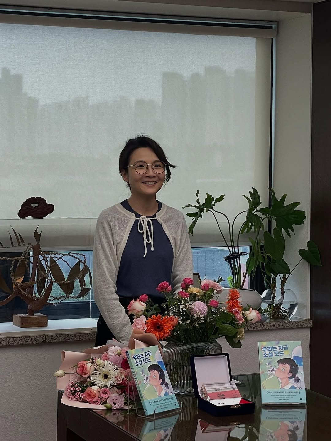 Photo by 현대문학 on September 30, 2025. May be an image of 2 people, flower arrangement, prairie gentian, carnation, office and text.