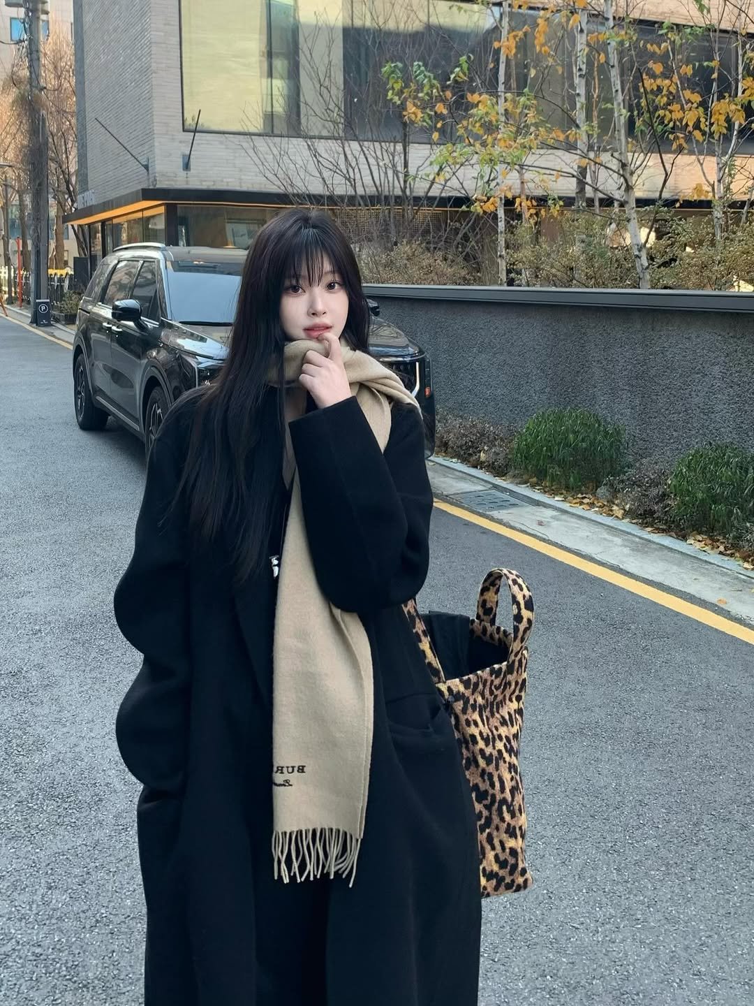 Photo shared by 최희진 on December 05, 2025 tagging @songzio_official. May be an image of one or more people, hair, duffle coat, overcoat, scarf, turtleneck, parka and text.