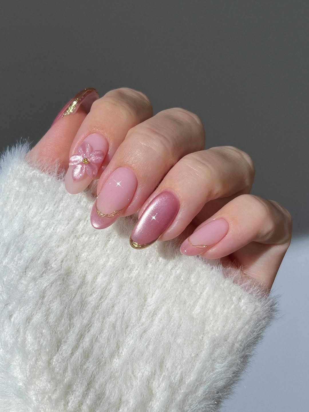 Pink glass nails, cat eye nails, pastel pink , spring nails, glassy silky cat eye gel, flower nails, 3D floral nails, gold french tip nails, pink nude almond nails, chunky gold swirl ring with diamonds, purple lavender lilac swirl nails, glossy shimmery velvet an silk nails, gradient nails, open gold ring with tear drop amethyst, gold twisted ring, sage green an caramel brown glittery glass nails, stripe nails, polka dot nails, sweater nails, beige nails, winter to spring nails, dainty dotted gold ring, ribbed gold ring,