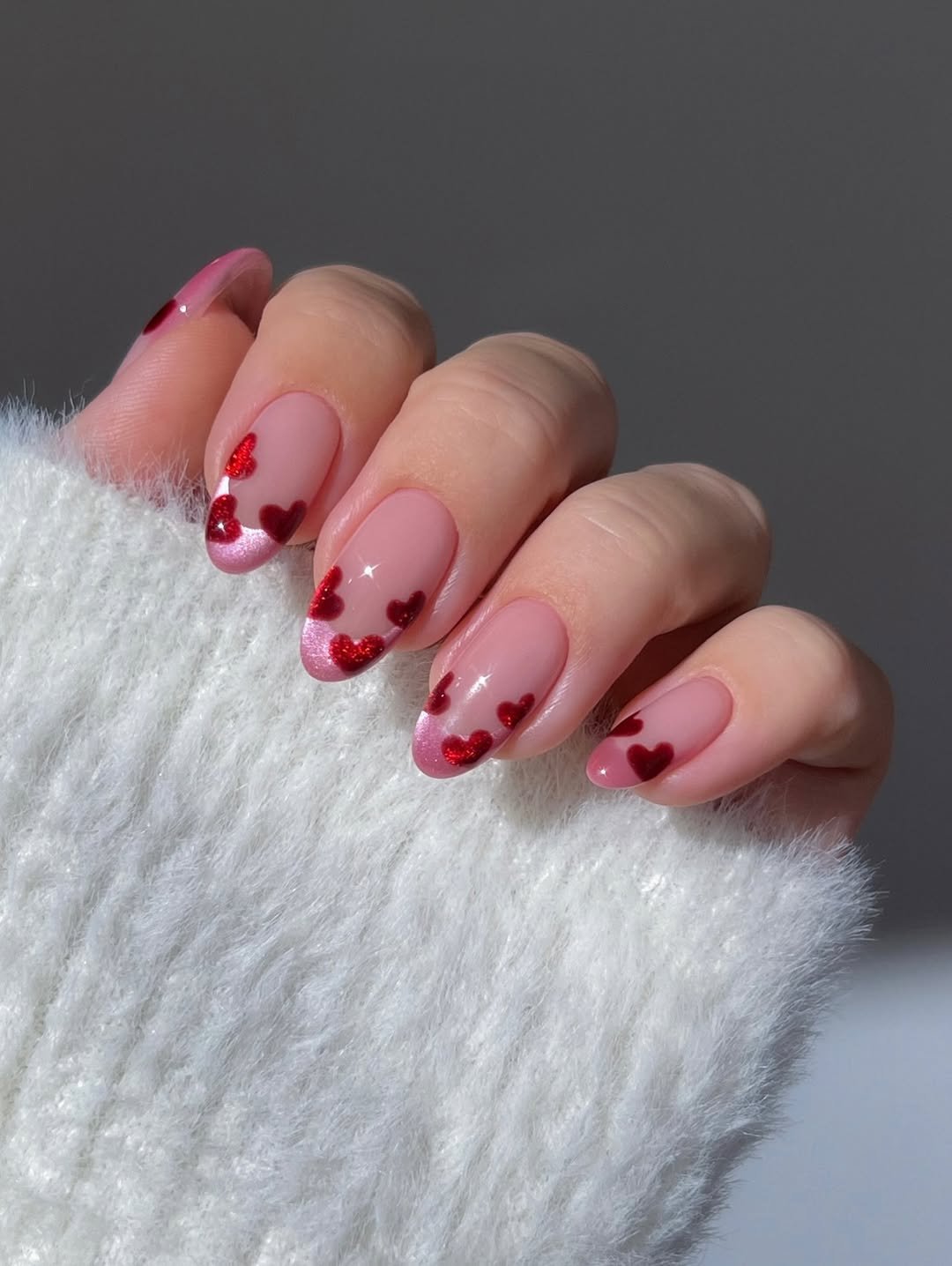 Pink French velvet tips with red velvet hearts, Valentine’s Day nails, vday nails, cat eye nails, nude nails almond nails, dainty gold ring with dangle heart, gold ring with pink gem, Burgundy velvet heart nails, sparkly nails, dark red nails, gold eternity heart ring, white ombre nails with red and pink glitter kisses, reflective glitter, gradient nails, rose gold love word ring,