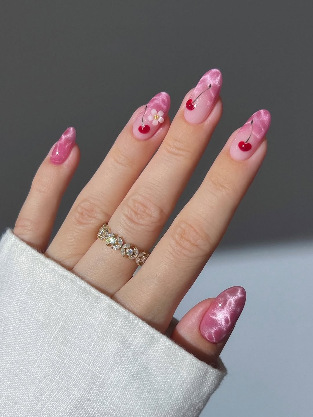 Pink sparkly water ripple nails with 3D cherries and flower, ombre nails, cherry blossoms nails, gradient nails, pool nails, red nails, spring nails summer nails, marquise cut floral pattern gold eternity ring, yellow orange pink blue green marble nails, glazed nails, pearl chrome nails, candy nails, neon pastel nails, dainty rainbow eternity ring, purple orange pink glassy marble nails, velvet nails, gold butterfly nails, dainty gold rings with dangling butterflies and flowers,